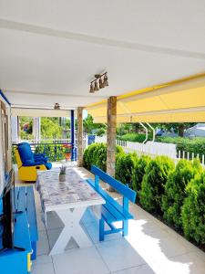 a patio with a blue bench and a table at Villa Blue House in Nea Kallikrateia