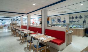 a dining room with tables and chairs and a counter at Medplaya Hotel Riudor - Adults Recommended in Benidorm