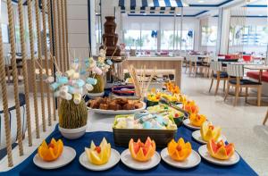 a buffet of food on a table with plates of food at Medplaya Hotel Riudor - Adults Recommended in Benidorm