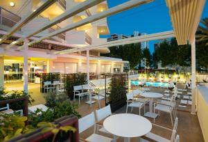 a restaurant with tables and chairs and a pool at Medplaya Hotel Riudor - Adults Recommended in Benidorm