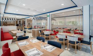 a restaurant with wooden tables and red chairs at Medplaya Hotel Riudor - Adults Recommended in Benidorm