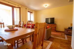 une salle à manger avec une table et une télévision dans l'établissement ELL001 Casa adosada de 2 dormitorios, à Ayamonte