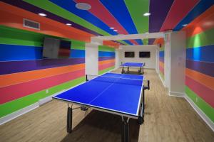 a room with a ping pong table in front of a colorful ceiling at Hotel Zed Victoria in Victoria