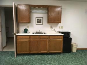 a kitchen with a sink and wooden cabinets at Value Host Marquette in Marquette