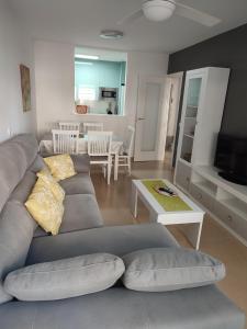 a living room with a gray couch and a table at Apartamento Alegria in Garrucha