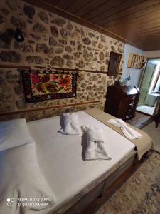 a bedroom with a bed with towels on it at Bayiri Petit Pension in Litochoro