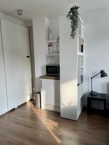 a living room with white walls and wooden floors at Apartment in Pempelfort - Central in Düsseldorf +21 photos
