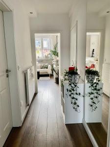 デュッセルドルフにあるアパートメント イン ペンペルフォルト セントラルの白い壁と床、植物のあるリビングルーム