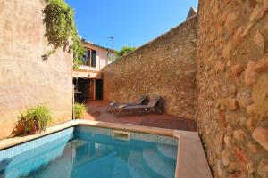 a swimming pool in front of a stone wall at Casa Anita 257 by Mallorca Charme in Binissalem