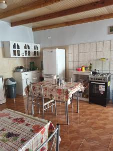 a kitchen with a table with chairs and a refrigerator at Hostal Casa Flores in San Pedro de Atacama