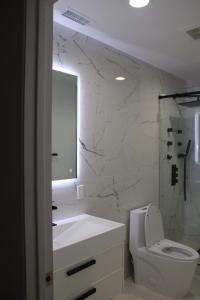 a bathroom with a toilet and a sink and a mirror at Pearl Beach Villa Huntington Beach in Huntington Beach