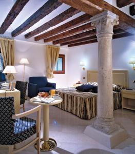 a hotel room with a bed, table and chairs at Hotel Giudecca Venezia in Venice
