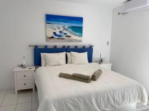 コスタ・テギセにあるCasa Linda 2 bed apartment in Costa Teguiseのベッドルーム(白いベッド、青いヘッドボード付)
