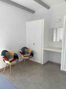 two chairs sitting in a room with white walls at Maganiotis Rooms in Kimolos