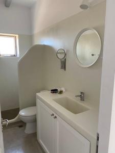 a bathroom with a sink and a toilet and a mirror at Maganiotis Rooms in Kimolos