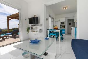 a kitchen and living room with a glass table at White Blue Villa in Lakhania