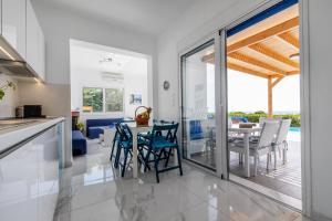 a kitchen and dining room with a table and chairs at White Blue Villa in Lachania
