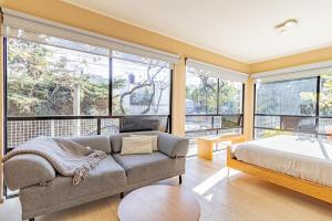 1 dormitorio con sofá, cama y ventanas en Mi Zona Lodging WTC, en Ciudad de México