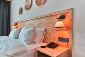 Schlafzimmer mit einem Bett, einem Telefon und einer Lampe in der Unterkunft The Pearl Ölüdeniz in Oludeniz