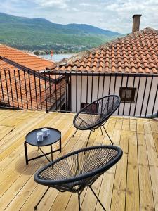 two chairs and a table on a wooden deck at Wild Pear Old Town boutique accommodation in Ohrid