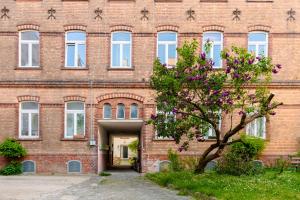 ein Backsteingebäude mit einem Baum davor in der Unterkunft Home by Doni I serviced apartments I ruhig I zentral nahe RMCC, Staatsheater & Landtag in Wiesbaden + 5 Fotos