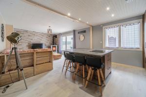um quarto com uma cozinha com um bar com bancos em Le Loft em Ornans