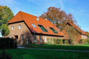 a large brick house with an orange roof at Meine Schule Sehlingen, Familien-Apartment mit Sauna & Spielplatz! in Kirchlinteln