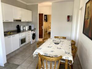 a kitchen with a table with chairs and a kitchen with white cabinets at Casa Louise in Costa Teguise