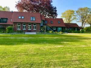a large house with a large yard in front of it at Meine Schule Sehlingen, Familien-Apartment mit Sauna & Spielplatz! in Kirchlinteln
