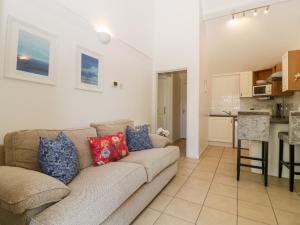 ein Wohnzimmer mit einem Sofa und einer Küche in der Unterkunft Swallow Cottage in Shaftesbury