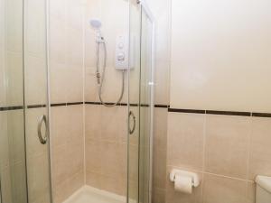 y baño con ducha y puerta de cristal. en Swallow Cottage, en Shaftesbury