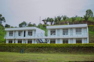um edifício branco no topo de uma colina em Hotel Takuara em Vergara