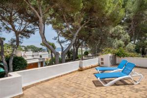 two blue chairs sitting on a patio with trees at Wonderful 5 Bed Villa With Private in Cacla D'or