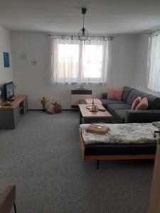 ein Wohnzimmer mit einem Sofa und einem Tisch in der Unterkunft Chalupa u Rádlů in Domažlice