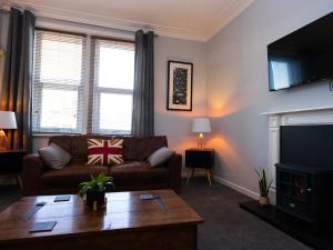 a living room with a couch and a fireplace at Marden Mews in Whitley Bay