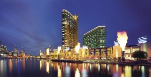a city with buildings and a river at night at Crown Towers Melbourne in Melbourne