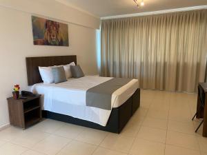 a bedroom with a large bed in a room at Miami Hotel by H Hotéis - Business in Taguatinga