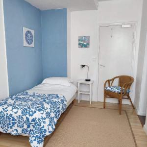 1 dormitorio pequeño con 1 cama y 1 silla en Les Chenes Chambres D'hote en Châtel-Guyon