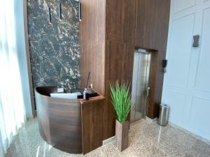 a bathroom with a wooden tub with a plant in it at Miami Hotel by H Hotéis - Business in Taguatinga