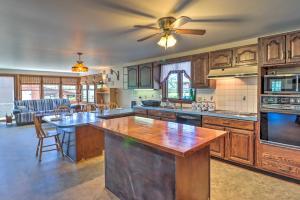 a large kitchen with wooden cabinets and a ceiling fan at Lovely Mifflinburg Farmhouse - Multiple Decks in Mifflinburg