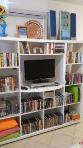 uma prateleira de livros brancos cheia de livros e uma televisão em Old Town Charmer em Poreč