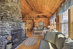 a living room with a stone fireplace and a couch at Charming Ocean-View Cottage By Cutler Harbor in Cutler