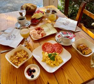 a wooden table with plates of breakfast foods and drinks at Hostal Restaurante Pou des Lleó in Sant Carles de Peralta