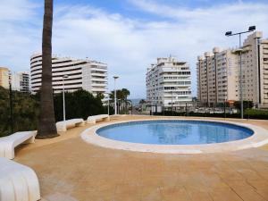 una piscina en medio de una ciudad con edificios altos en ACOGEDOR ADOSADO entre mar y montaña en Cullera