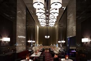 a dining room with tables and a large chandelier at Crown Towers Melbourne in Melbourne