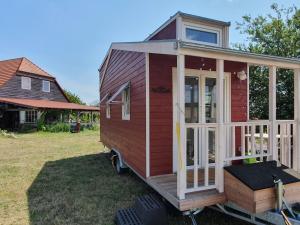 una casita roja estacionada en un patio en Tiny House en Schönbeck