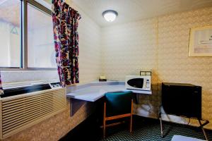 een kleine kamer met een tafel en een magnetron bij OYO Hotel Chapmanville Inn, WV - Hwy 119 in Chapmanville