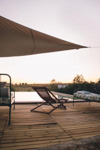 a couple of chairs and a tent on a deck at Casa do Vagar in Vimieiro