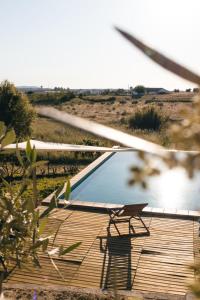 a chair sitting on a wooden deck next to a pool at Casa do Vagar in Vimieiro