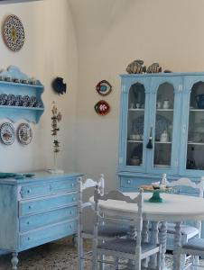 ein Esszimmer mit blauen Schränken sowie einem Tisch und Stühlen in der Unterkunft Argenta 111 Santa Tecla Acireale in Acireale
